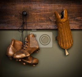 botas-de-futebol-do-vintage-e-protetor-de-canela-pendurado-em-um-vestiario-400-1376271.jpg